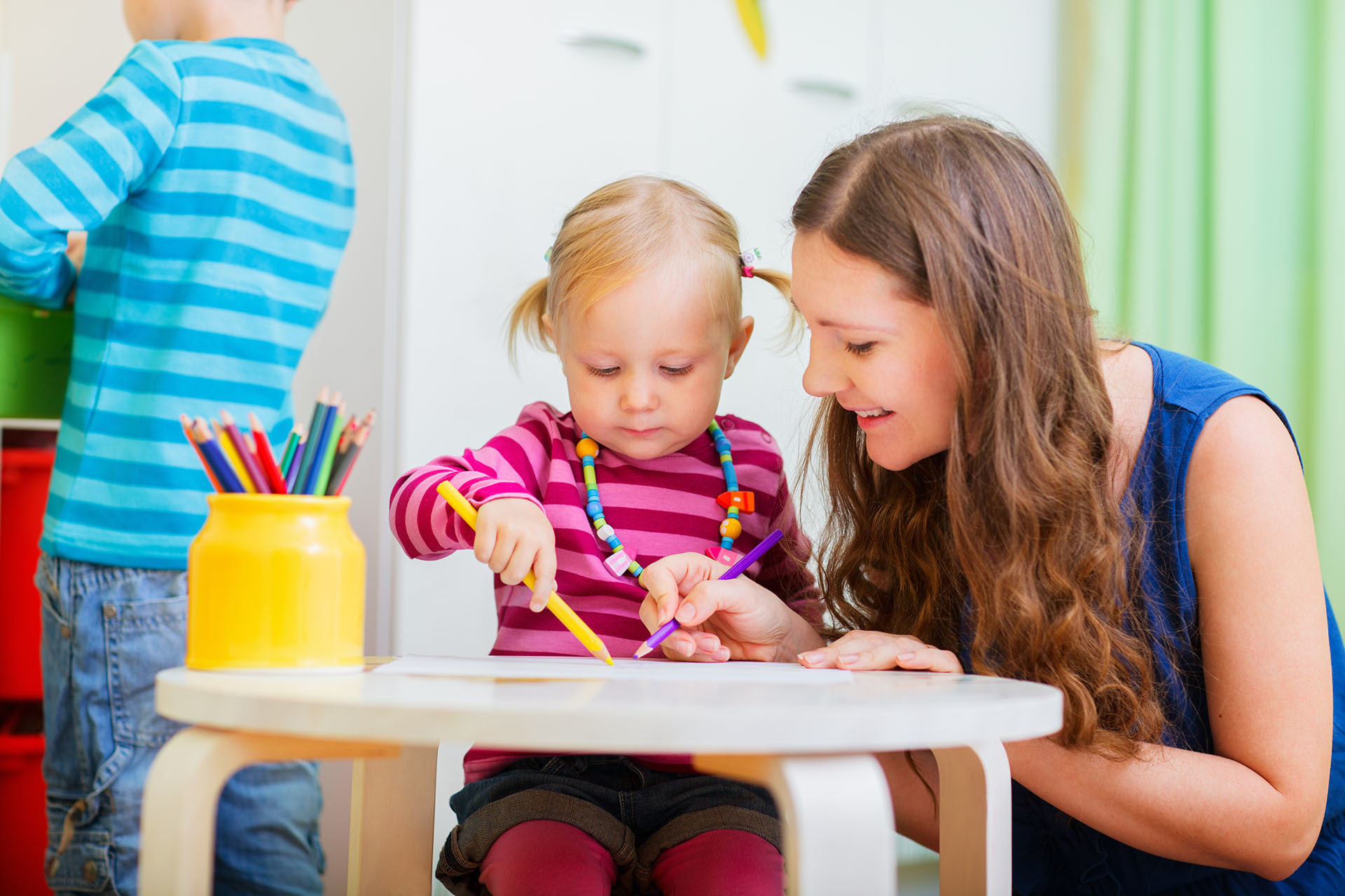 girl drawing with childcarer