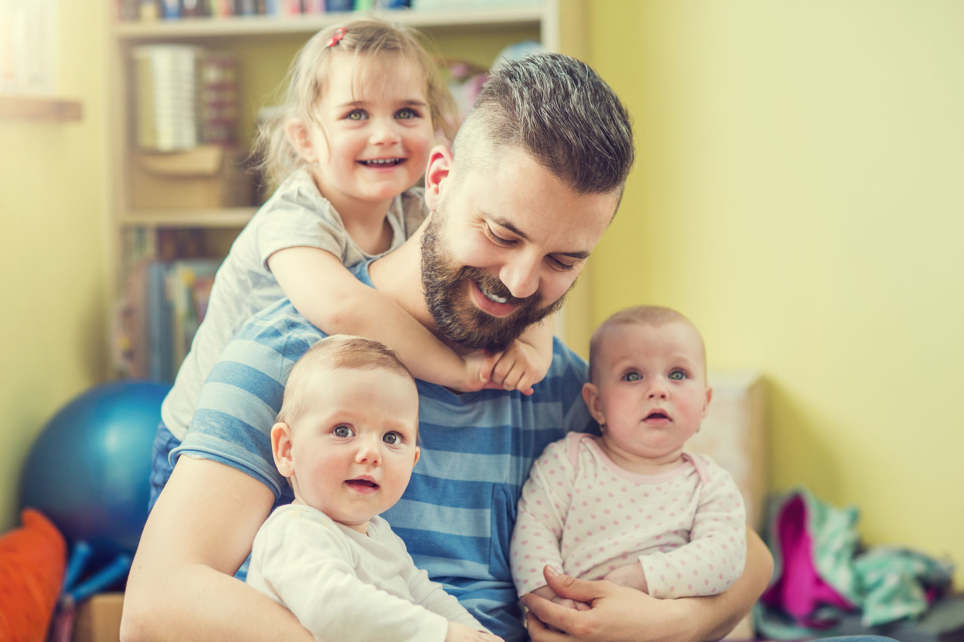 man in striped tshirt with three children