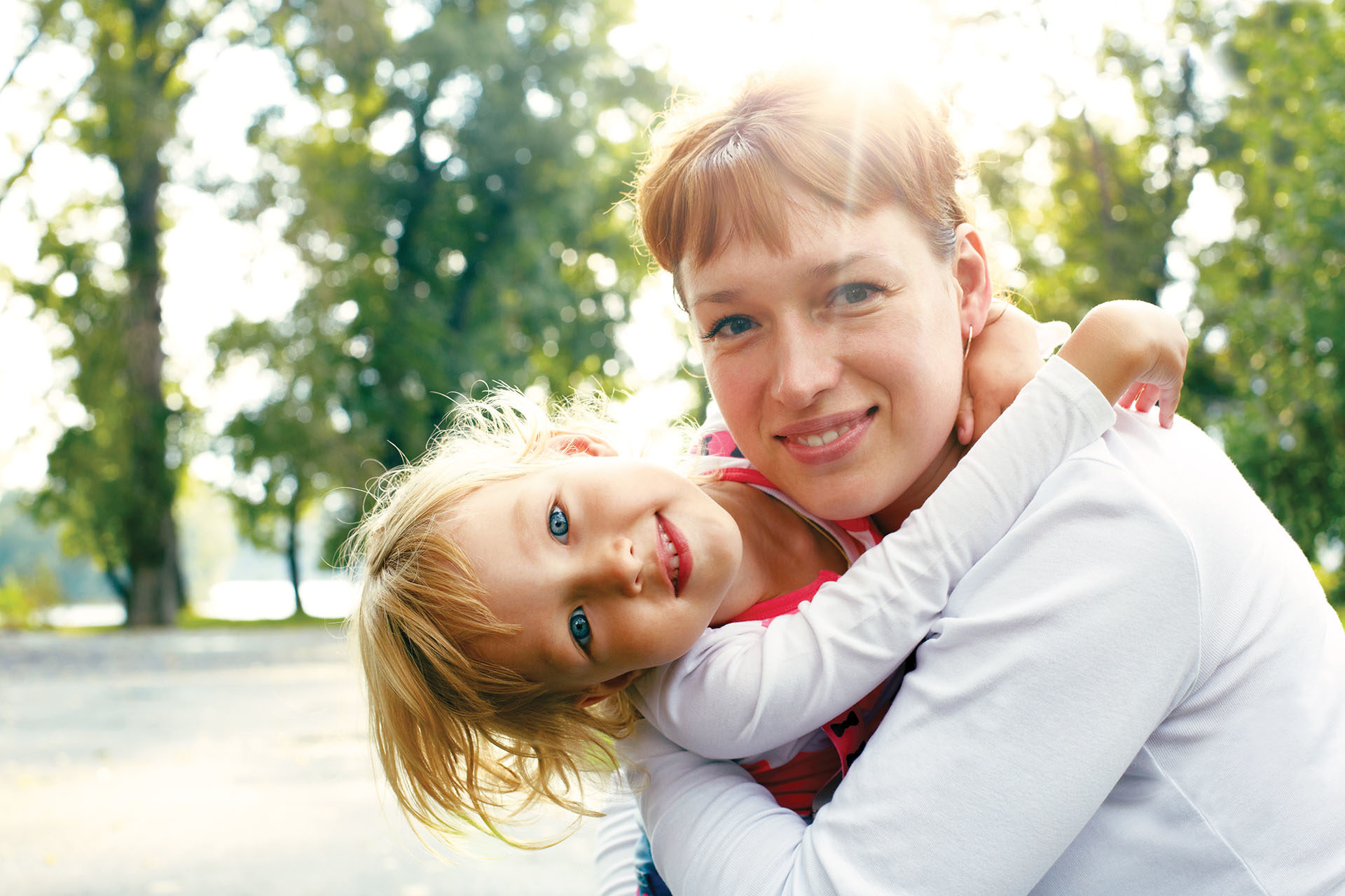 woman and girl hugging outdoors