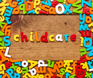 Multi coloured magnetic letters spelling out childcare on a wooden background